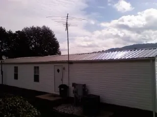 New metal roof on a single wide mobile home with a TV antenna in Melbourne Beach