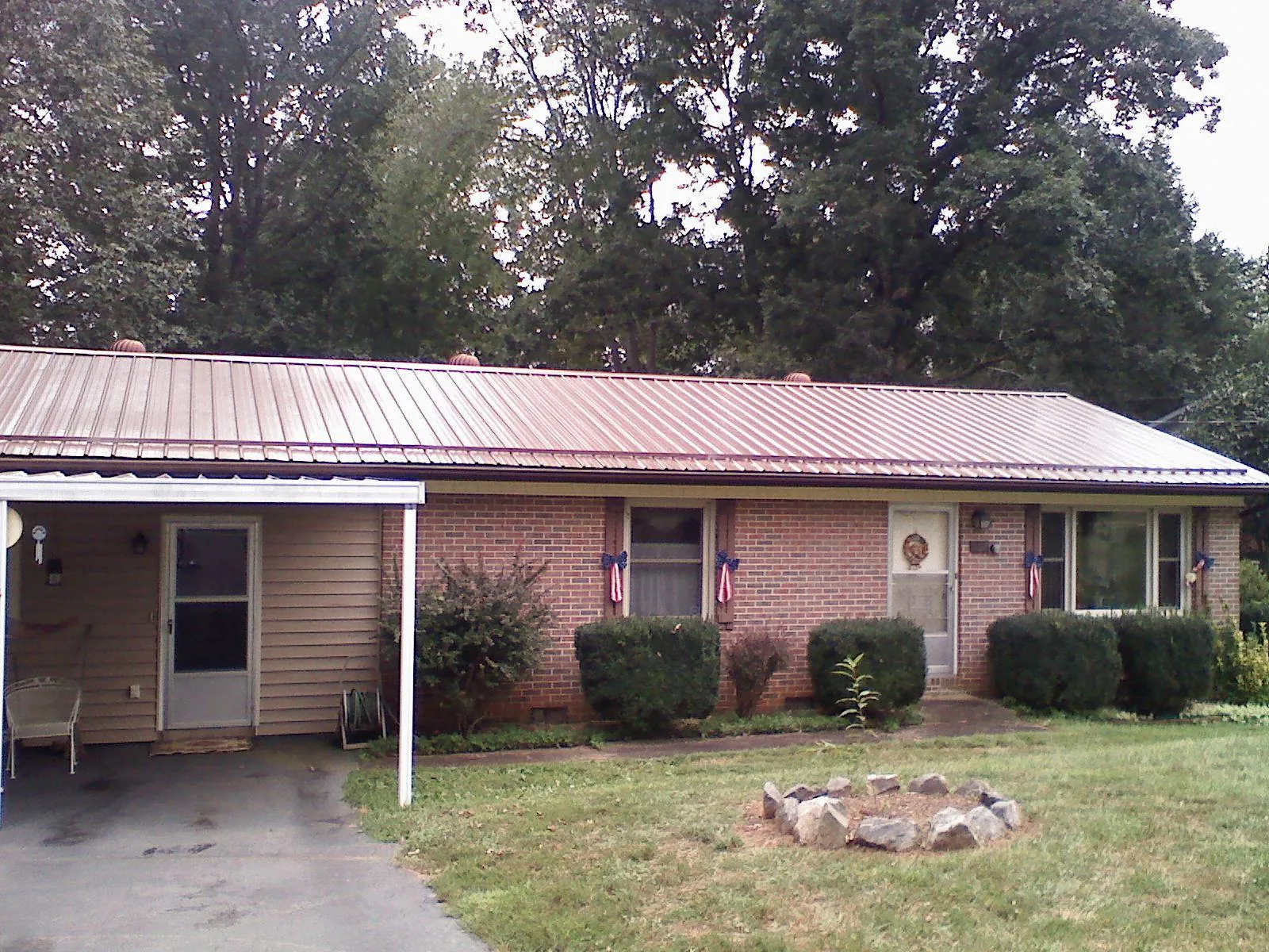 Bronze metal roof and carport on a brick ranch home — Roof Repair work by our crew in Melbourne Beach